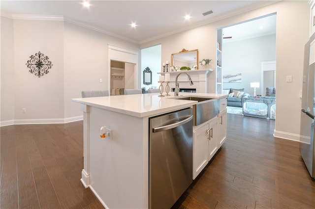 kitchen with stainless steel dishwasher, white cabinets, a center island with sink, and dark wood-type flooring