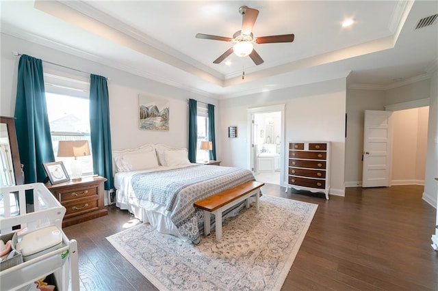 bedroom featuring ensuite bath, ceiling fan, a raised ceiling, dark hardwood / wood-style flooring, and ornamental molding