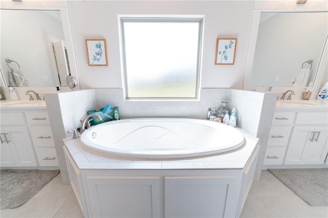 bathroom featuring vanity, tile patterned flooring, and a relaxing tiled tub