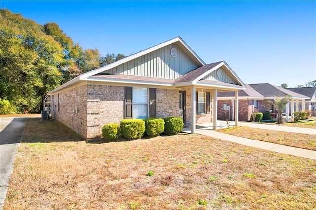 view of front of property with a front yard and central air condition unit