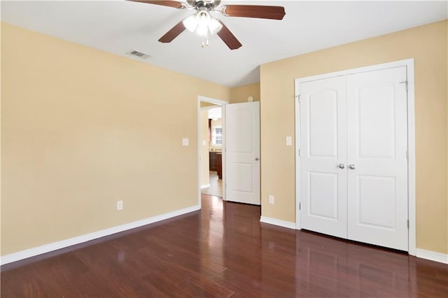 unfurnished bedroom with dark wood-type flooring, ceiling fan, and a closet