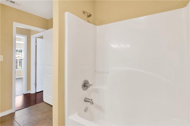 bathroom with tile patterned flooring and bathtub / shower combination