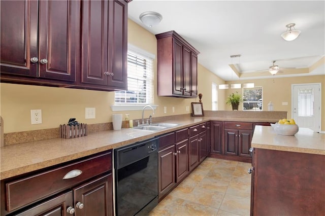 kitchen with kitchen peninsula, black dishwasher, sink, ceiling fan, and a tray ceiling