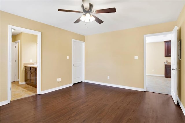 interior space with ceiling fan, dark hardwood / wood-style floors, sink, and ensuite bath