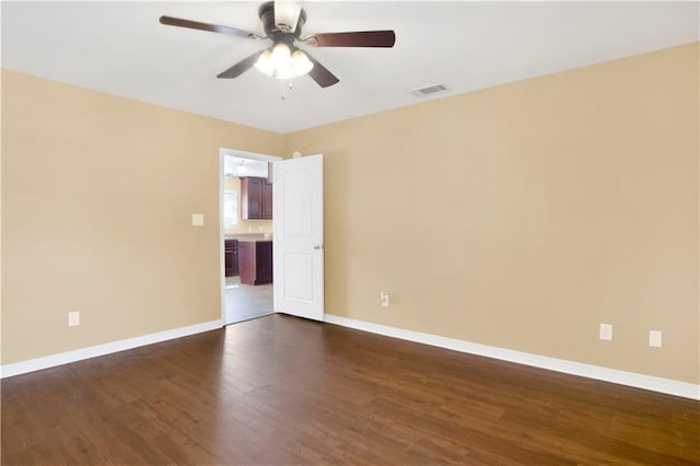 unfurnished room featuring dark wood-type flooring and ceiling fan