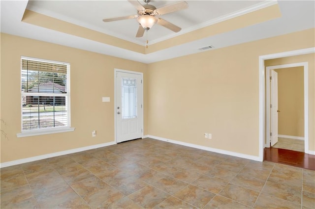 unfurnished room featuring a raised ceiling and ceiling fan