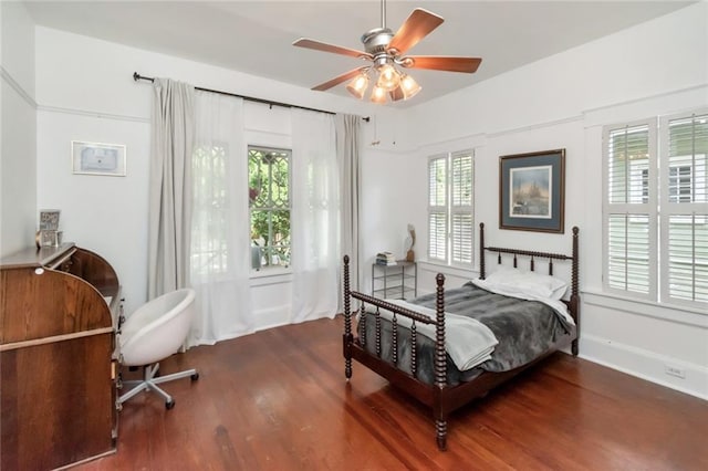 bedroom with multiple windows, wood finished floors, and a ceiling fan
