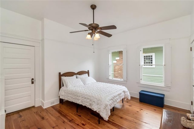 bedroom featuring baseboards, hardwood / wood-style floors, and ceiling fan