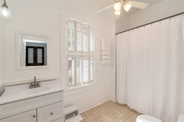 bathroom featuring toilet, vanity, curtained shower, tile patterned floors, and ceiling fan