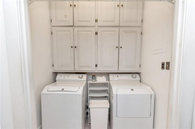 laundry area featuring washing machine and clothes dryer and cabinet space