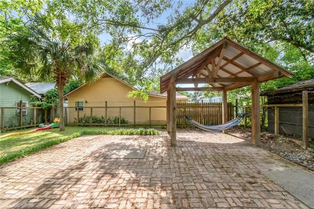 view of patio / terrace with a detached carport, a playground, a gazebo, and a fenced backyard