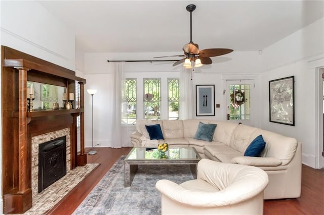 living room featuring a ceiling fan, dark wood finished floors, and a fireplace