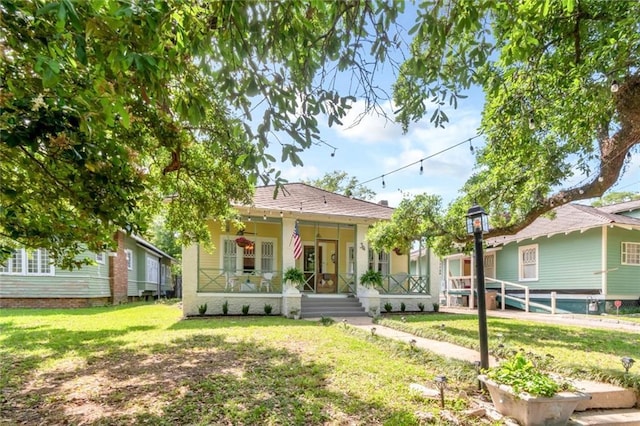 bungalow with a front yard, a porch, and fence