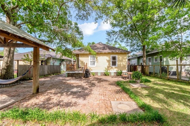 back of house featuring a yard, a patio area, and a fenced backyard