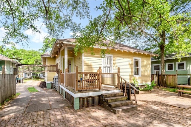 rear view of property featuring fence and a patio area
