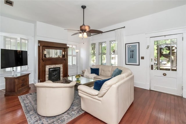 living room featuring visible vents, plenty of natural light, and dark wood-type flooring