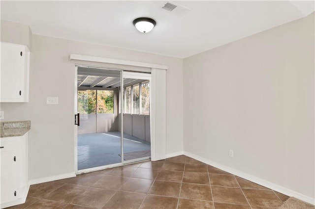 doorway with dark tile patterned floors