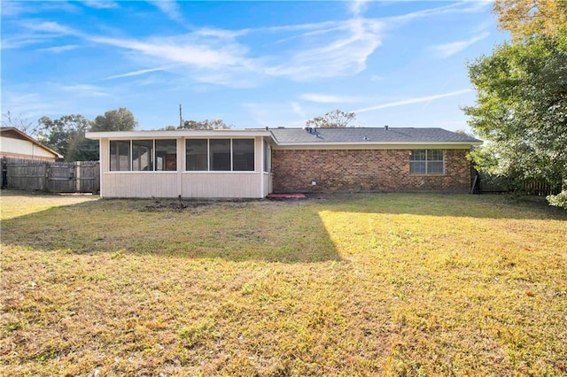 back of house featuring a yard and a sunroom