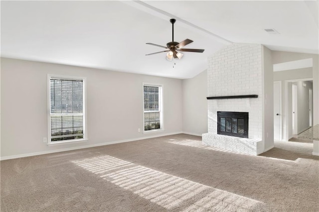 unfurnished living room featuring a brick fireplace, light colored carpet, lofted ceiling, and ceiling fan