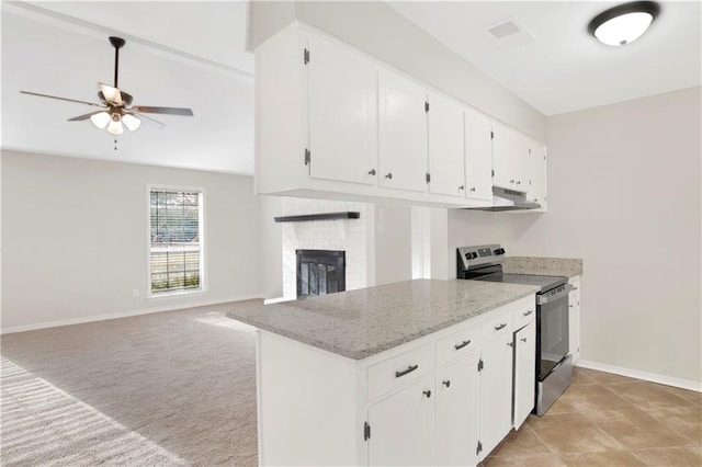 kitchen with stainless steel electric range oven, light colored carpet, a fireplace, light stone countertops, and white cabinets