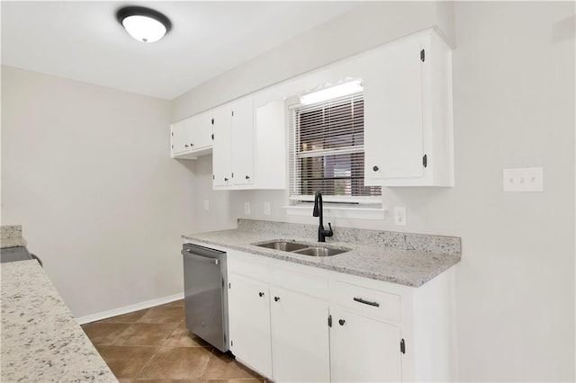 kitchen with tile patterned floors, sink, white cabinetry, light stone counters, and dishwasher