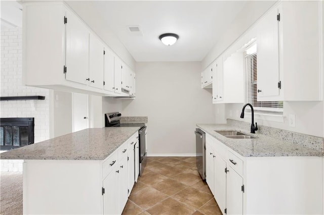 kitchen featuring sink, white cabinetry, stainless steel appliances, a fireplace, and light stone countertops