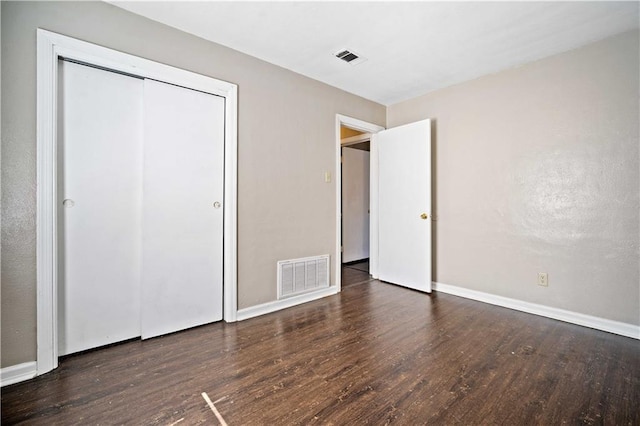 unfurnished bedroom with visible vents, baseboards, and wood finished floors