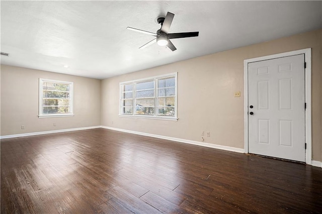 unfurnished living room with dark wood-style floors, visible vents, ceiling fan, and baseboards