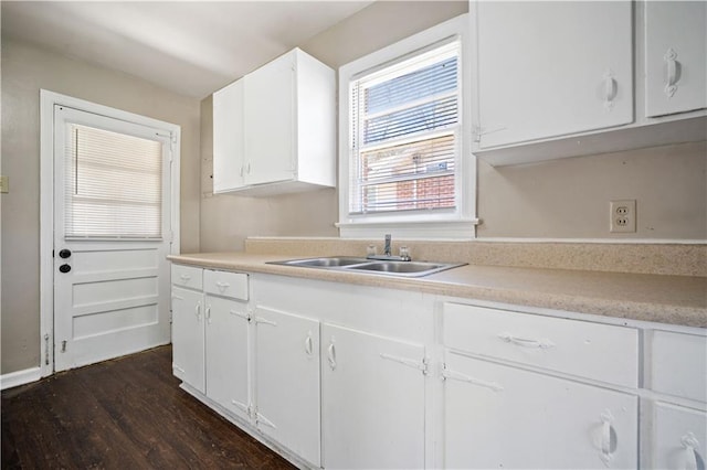 kitchen with a sink, dark wood-type flooring, light countertops, and white cabinetry