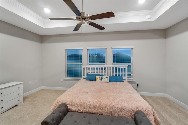 carpeted bedroom featuring ornamental molding, ceiling fan, and a tray ceiling