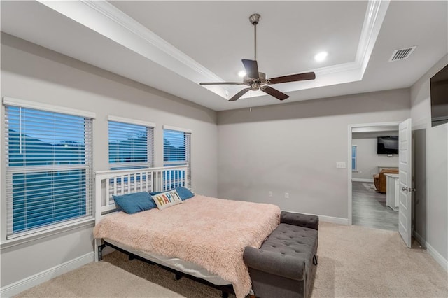 bedroom with ceiling fan, ornamental molding, a raised ceiling, and light carpet