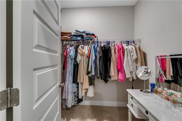 walk in closet featuring dark carpet