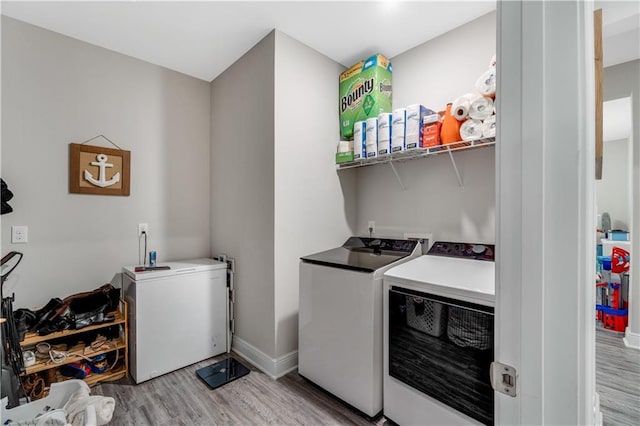 laundry room featuring light hardwood / wood-style flooring and washing machine and clothes dryer