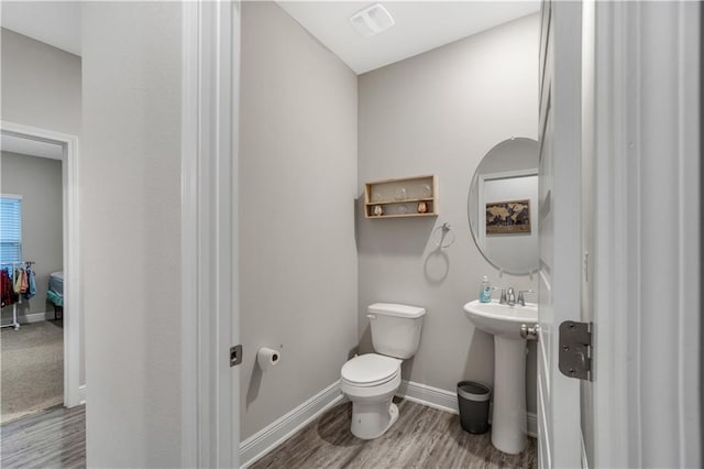 bathroom with hardwood / wood-style flooring, sink, and toilet