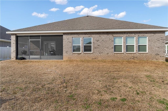 back of house featuring a yard and a sunroom