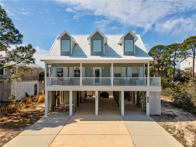 coastal home featuring a porch, a carport, and concrete driveway