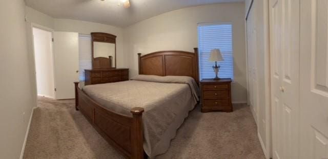 bedroom with light carpet and baseboards