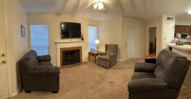 living room with light carpet, ceiling fan, and a brick fireplace