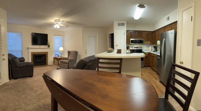 interior space featuring stainless steel appliances, light countertops, visible vents, open floor plan, and ceiling fan