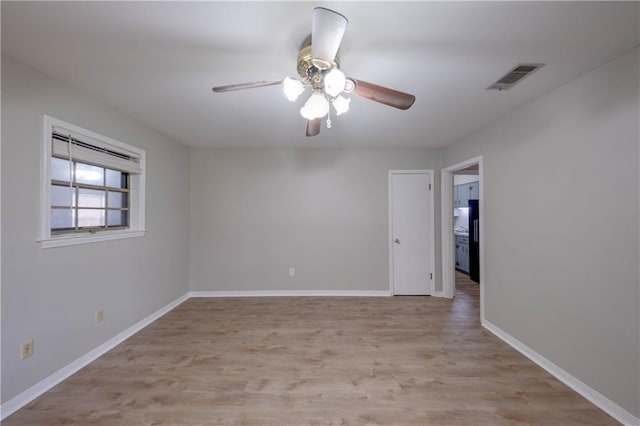 empty room with ceiling fan and light wood-type flooring