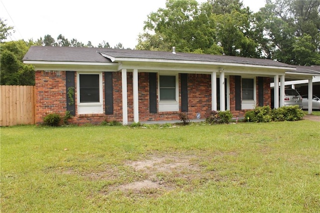 ranch-style home featuring a front lawn and a carport