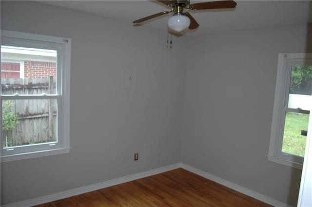 unfurnished room featuring ceiling fan, wood-type flooring, and a wealth of natural light