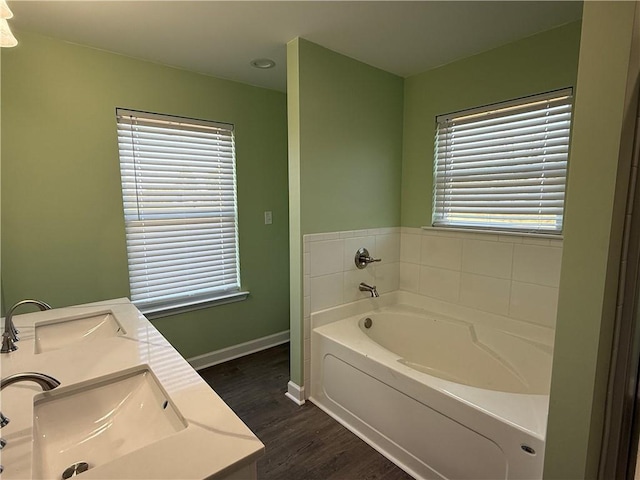 bathroom with hardwood / wood-style floors, a washtub, and vanity