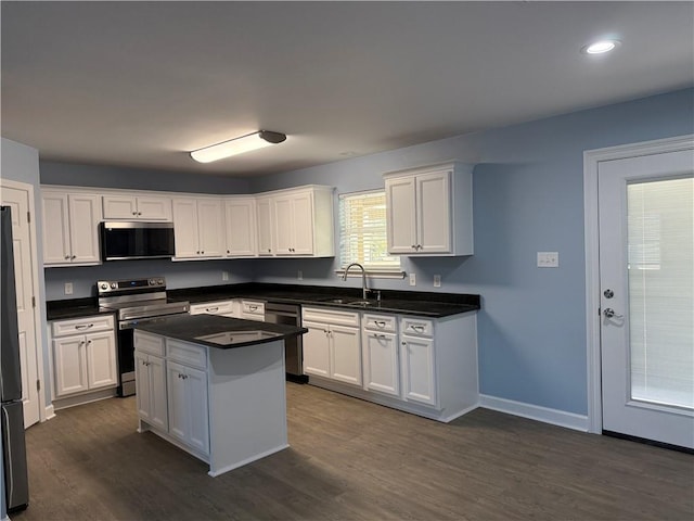 kitchen featuring sink, a kitchen island, dark hardwood / wood-style flooring, white cabinetry, and stainless steel appliances