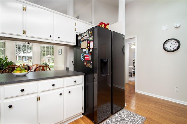 1000 Pinemont Dr, Mobile, AL 36609 - kitchen with fridge with ice dispenser, light wood-style floors, dark countertops, and white cabinets