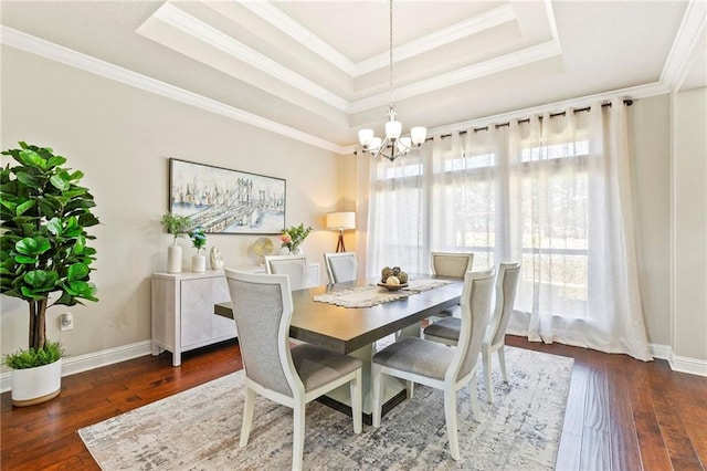 dining area featuring dark hardwood / wood-style flooring, a tray ceiling, an inviting chandelier, and crown molding