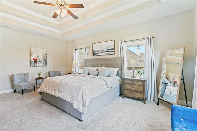 carpeted bedroom featuring a tray ceiling, ceiling fan, and crown molding