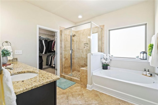 bathroom featuring tile patterned flooring, vanity, and shower with separate bathtub