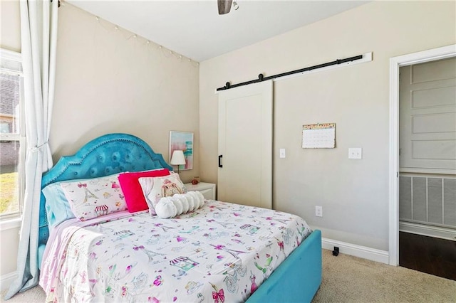 bedroom with carpet, a barn door, and ceiling fan