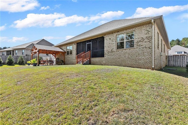 back of property featuring a lawn and a sunroom